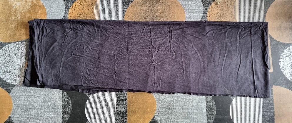 Long tissu sombre étendu sur surface à motifs