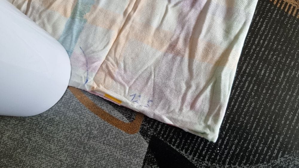 Chiffon taché posé sur tapis près d’un bidon